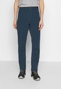 Navy blue outdoor pants with a smooth texture, featuring a fitted design, two front pockets, and reinforced stitching along the seams.