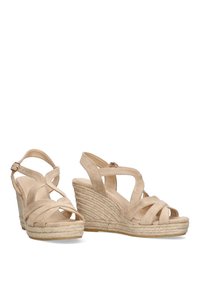 Sandalias de cuña beige con diseño de correas cruzadas, hechas de suave ante, con suela de yute trenzado y hebilla en el tobillo para ajustabilidad.