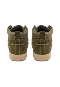 Scarpe alte in suede verde con colletto imbottito, suola in gomma beige e cuciture decorative sul tallone e sul lato. Presentano una linguetta sul retro.