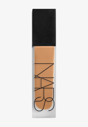 Flüssigfoundationsflasche mit mattiertem Glas, schwarzem Deckel und schwarzem "NARS"-Logo auf beige getönter Makeup-Flüssigkeit innen.