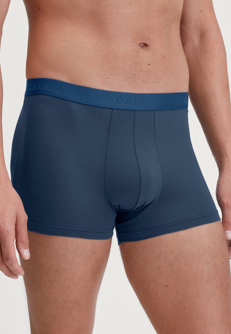 Navy blauwe boxershorts met een zachte, elastische tailleband met de merknaam "CALIDA." Gemaakt van glad materiaal met een aansluitend ontwerp.