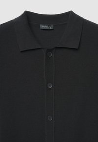 Schwarzes, geripptes Strick-Poloshirt mit Kragen, ausgestattet mit einer Knopfleiste und zwei Knöpfen, gefertigt aus strukturiertem Stoff. Markenetikett sichtbar.