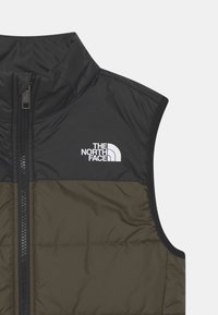 Vadderad �ärmlös jacka i olivgrönt och svart, med dragkedja framtill och den vita logotypen för The North Face på bröstet.