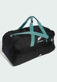 Sort duffelbag med teal håndtag, med lynlås-lukning, mesh sidelomme og "All Blacks"-logo på siden.