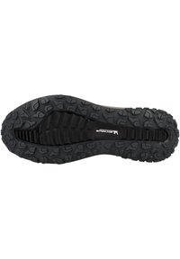 Suola di scarpa da trail running realizzata in materiale gommoso nero, con scanalature profonde per la trazione, una superficie testurizzata e una fessura stretta lungo il centro.