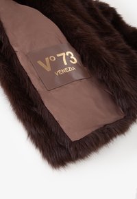 Gilet in pelliccia sintetica marrone con una fodera interna marrone liscia. Presenta un'etichetta rettangolare in pelle con la scritta "V°73 VENEZIA" in oro.