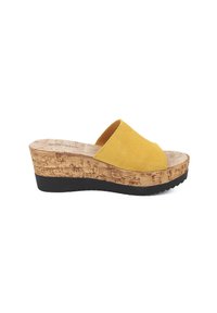 Sandal con zeppa in suede giallo, dotata di una piattaforma in sughero, punta tondeggiante e suola in gomma nera texturizzata. Progettata per essere indossata senza laccio.
