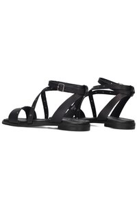 Zwarte leren sandalen met verschillende bandontwerpen, studaccenten en een gespsluit enkelband. Platte zool met minimale textuur.