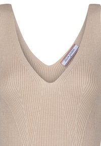 Beesinine ribidega kootud tank top sügava V-kaelusega, millel on vertikaalsed jooned ja brändi silt kaeluses.