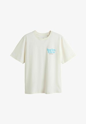 Weißes T-Shirt mit kurzen Ärmeln und blauem Text "Ocean Views By the Sea with Volkswagen" auf der linken Brust.