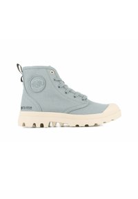 Stivali alla caviglia in tela blu chiaro con suola in gomma beige, caratterizzati da un logo circolare, occhielli in metallo e design con lacci. Parte superiore testurizzata.