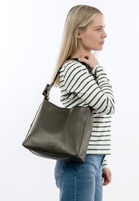 Czarna skórzana torba na ramię o gładkiej fakturze, prostokątnym kształcie i jednym pasku. Posiada subtelne logo z przodu.