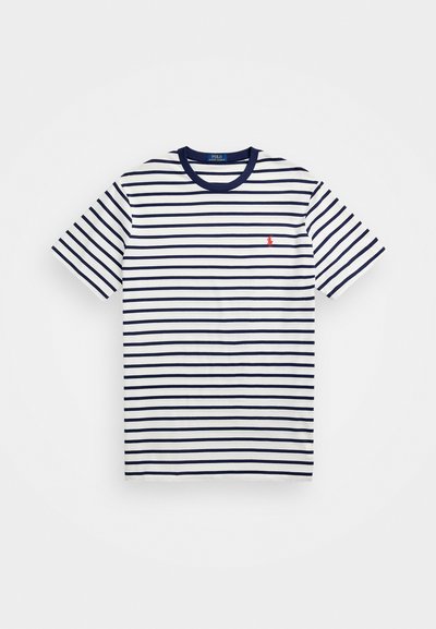 Ριγέ μπλούζα σε λευκό και ναυτικό μπλε, κοντά μανίκια, στρογγυλή λαιμόκοψη, διαθέτει ένα μικρό κόκκινο λογότυπο στο αριστερό στήθος, φτιαγμένη από βαμβακερό ύφασμα.