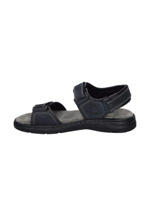 Black leather sandal features adjustable straps, padded footbed, and textured gray insole with visible stitching. Lightweight rubber sole.