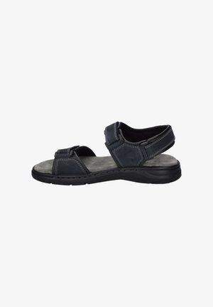 Black leather sandal features adjustable straps, padded footbed, and textured gray insole with visible stitching. Lightweight rubber sole.