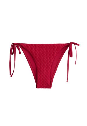 Piros, texturált bikini alsó oldalt megkötve mindkét csípőnél, fehér háttér előtt.