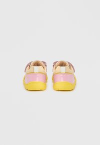 Πολύχρωμα παιδικά παπούτσια με κίτρινη σόλα, τακούνι από ροζ λουστρίνι και απαλούς, υφασμένους ιμάντες σε ροζ και μπεζ.