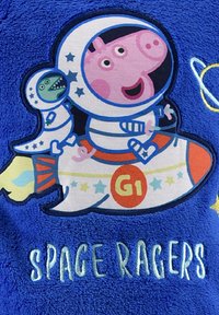 Tejido de felpa azul con un cohete de dibujos animados y personajes en trajes espaciales. Texto "SPACE RAGERS" en verde, con estrellas y acentos coloridos.
