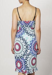 Hihaton mekko, jossa on istuva muotoilu, valmistettu värikkäästä kankaasta, jossa on monimutkaisia kukkakuoseja sinisen, vaaleanpunaisen ja valkoisen sävyissä, rypytetyllä helman osalla.