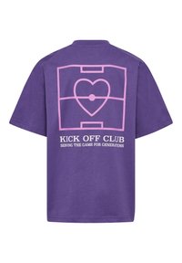 Lilla bomulds t-shirt med en pink grafik af et hjerte indenfor en fodboldbane omrids og teksten "KICK OFF CLUB" nedenfor.