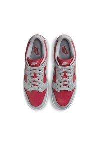 Nike-sneakers med övre i grå och röd läder, perforerad tå, grå snören och grå mellansula. Röd logotyp på tungan och innersulan.