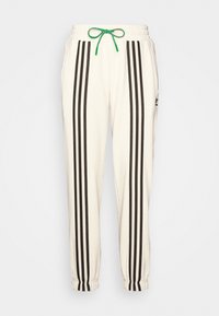 Pantaloni della tuta crema con strisce verticali nere, vita elastica, cordoncino verde e orli a doppio risvolto; dotati di tasche laterali e un'accento con logo.