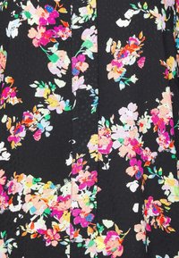 Floral patterned fabric in vibrant colors on a black background, featuring various flowers with green leaves and a textured surface.