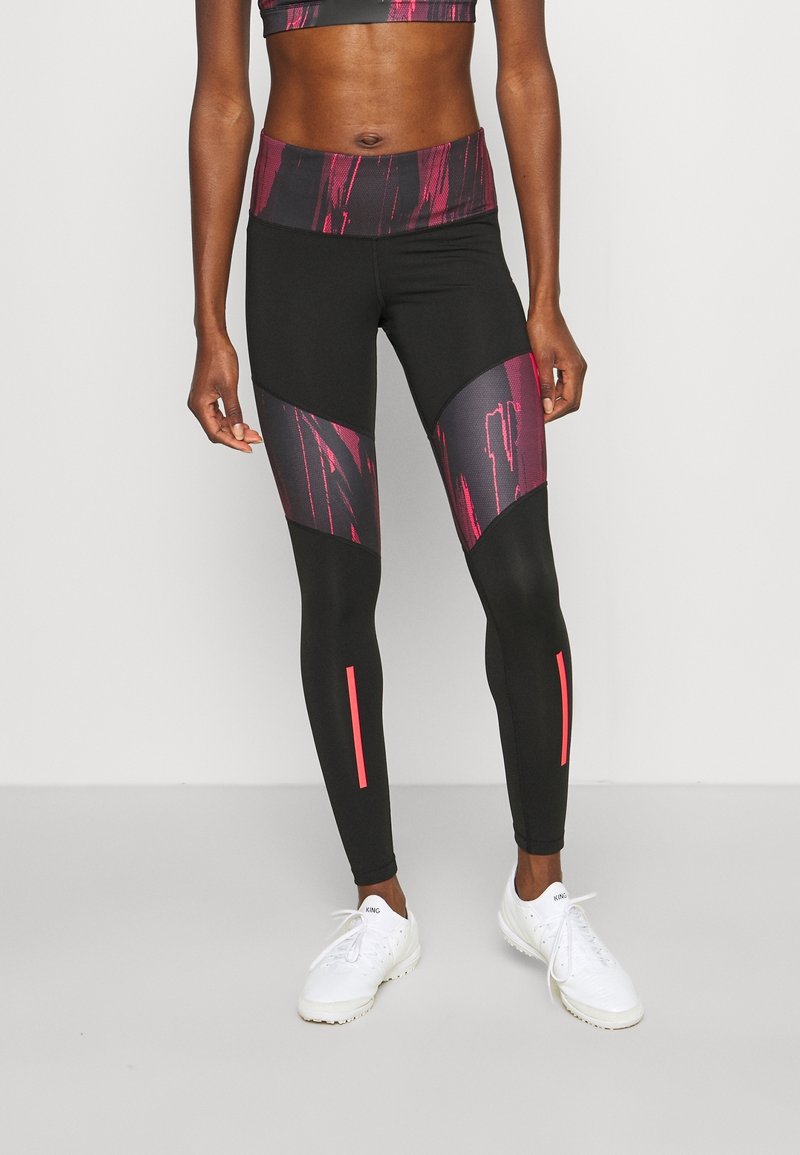 Černé legíny s vysokým pasem, na stehnech růžové abstraktní vzory a reflexní růžové prvky na spodních částech nohavic. Materiál se jeví jako pružný.