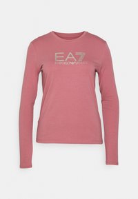 Långärmad, ljusrosa t-shirt gjord av mjukt tyg, med en silverfärgad EA7 Emporio Armani-logotyp över bröstet.