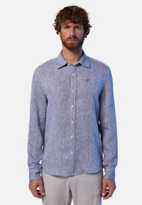 Camicia azzurra chiara a maniche lunghe realizzata in tessuto testurizzato, con colletto reversibile, bottoni frontali e un piccolo logo sul lato sinistro del petto.