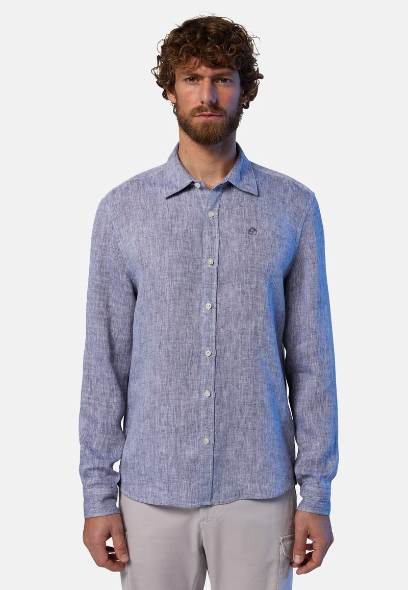 Camicia azzurra chiara a maniche lunghe realizzata in tessuto testurizzato, con colletto reversibile, bottoni frontali e un piccolo logo sul lato sinistro del petto.