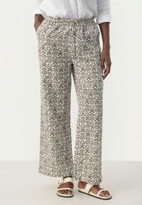 Lichte, crèmekleurige wijde broek met bruine abstracte patronen, voorzien van een elastische tailleband en een comfortabele pasvorm.