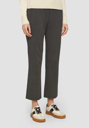 Grijze, lichte broek met een rechte pasvorm, voorzien van gestikte details en vo pockets, gecombineerd met witte en bruine sneakers.