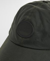 Boné verde escuro com uma coroa arredondada, apresentando um tecido texturizado, costura amarela e um emblema redondo em couro preto com "Barbour FARM Rio" em relevo.