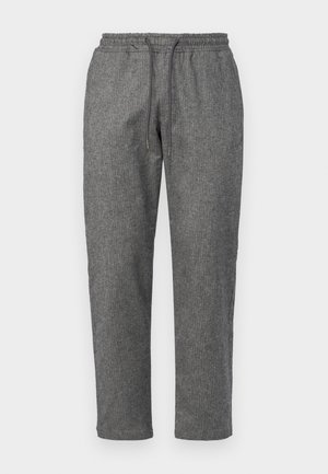 Pantaloni della tuta grigi, lavorati a maglia, con vita regolabile tramite cordoncino, gambe a sigaretta e un sottile motivo testurizzato su tutta la stoffa.