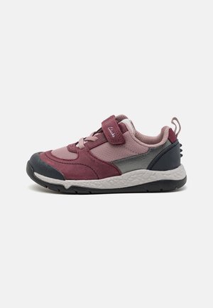 Kinderturnschuh mit oberem Teil aus kastanienbraunem Wildleder, pinken Netzpaneelen, grauen Akzenten und einer schwarzen Gummisohle. Verfügt über einen Klettverschluss und eine Zuglasche.