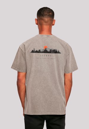 Gray cotton t-shirt with short sleeves. Back design features a city skyline silhouette and orange sun, with the word "ESCAPE."