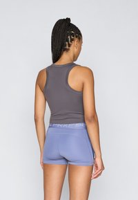 Débardeur gris et shorts bleu clair avec une taille à logo. Le haut présente un design dos nageur, et le tissu semble lisse et extensible.