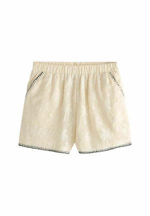 Pantaloni corti color crema con un motivo di palme, dotati di una cintura elastica, tasche laterali e cuciture nere a contrasto lungo l'orlo.