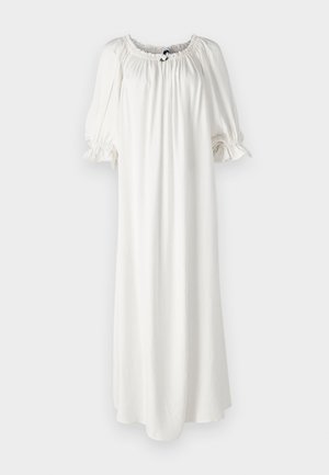 Fehér, lágy anyagból készült, bő sziluettű ruha, smockolt nyakkivágással és puffos ujjal, elöl egy diszkrét nyakkendő részlettel.