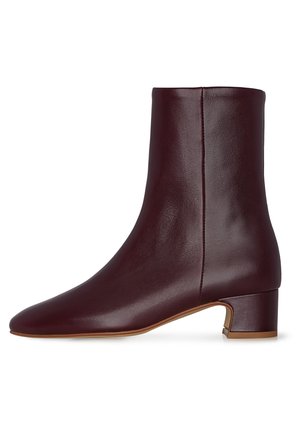 Stivale alla caviglia in pelle borgogna con punta affusolata, texture liscia e tacco basso a blocco. Presenta un dettaglio della cucitura laterale per un design aggiuntivo.