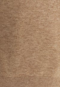 Tissu de pull en maille couleur fauve avec une apparence texturée et chinée. Comprend un ourlet côtelé et un détail similaire de côte le long des bords.