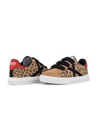 Zapatillas con estampado de leopardo, parte superior de ante color crema, detalles en textil negro y suela de goma blanca, con cordones negros y una lengüeta en el talón de color rojo.