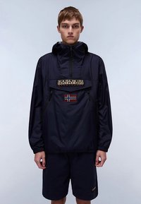 Granatowa nylonowa kurtka typu pulower z półzamkiem przy kołnierzu, naszywką z logo z przodu oraz detalem z flagą Norwegii. Posiada elastyczne mankiety i luźny krój.