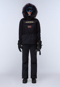Svart isolerad parka med fuskpäls på huven, bröstficka med en norsk flagga, i kombination med svarta byxor och handskar. Skyddsglasögon ingår.