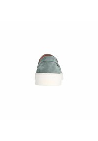 Groene suede instappers met een witte rubberen zool, met een ronde neus en een gladde textuur, gezien vanaf de achterkant.