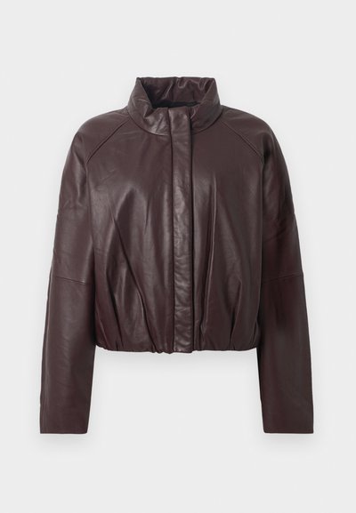 Veste cropped en cuir bordeaux avec un col montant, des manches raglan et une taille froncée. Texture lisse avec un minimum de détails.