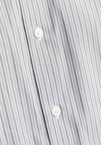 Gestreept overhemd met smalle blauwe en grijze verticale strepen, textuurstof en witte knopen langs de voorste sluiting.