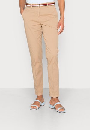 Beige gerade geschnittene Hose mit Seitentaschen und einem gestreiften Gürtel, getragen mit hellblauen offenen Sandalen mit niedrigem Blockabsatz.