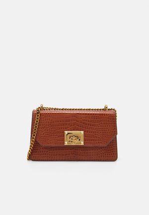 Brązowa skórzana torebka o fakturze krokodyla, z złotym prostokątnym zapięciem i złotym łańcuszkowym paskiem na jednolitym białym tle.